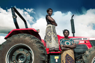 Kvinner står foran traktor