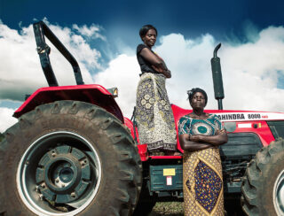 Kvinner står foran traktor