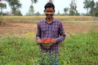 Bir fra Nepal viser frem noen av vekstene han dyrker