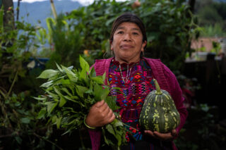 Kvinne viser fra grønnsaker fra åkeren sin