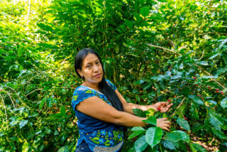 Kvinne viser fram kaffe på egen gård