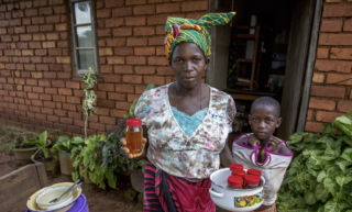 Familie i Malawi viser stolt frem matvarer