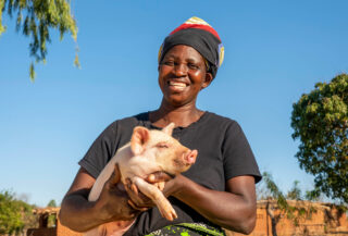 Bonden Patricia med grisen sin i Malawi