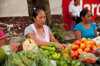 Kvinner selger mat på markedet